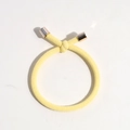 Detailed close-up of yellow braided elastic hair tie with rose gold metallic end caps - Light Yellow