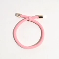 Detail of pink ribbed hair tie with golden metal ends and minimalist knotted design - Light Pink
