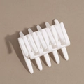 Macro shot of white matte finish hair claw clip for elegant bun styling on brown background - White