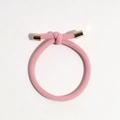 Detail of pink ribbed hair tie featuring a knotted design and gold metal tube ends - Pink