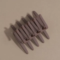 Detail view of large matte coffee hair claw clip with anti-slip teeth on beige background - Brown
