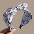 Close-up of bohemian paisley printed headband featuring a large bow and striped knot - Blue
