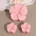 Detailed view of matte pale pink flower hair claw clips set against a minimalist background - Pink