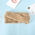 Close-up of beige knitted twist knot headband with ribbed texture on blue background - Khaki