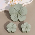 Macro shot of Morandi sage green flower hair claw clips with matte finish texture - Green