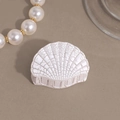 Macro shot of white shell-shaped hair claw with retro crackle texture detail - Small White Shells