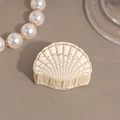 Detailed macro view of shell-shaped hair claw with cream finish and vintage cracked texture - Beige Small Shell
