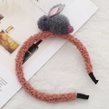 Overhead shot of a soft pink plush headband featuring a cute grey stuffed bunny detail - Tan