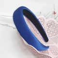 Nahaufnahme des königsblauen gepolsterten Satin-Stirnbands mit weicher Textur und Futter - Blau