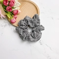 Detailansicht eines schwarz-weißen Scrunchie-Haargummis mit Karo-Muster aus weichem Stoff - Gitter Schwarz