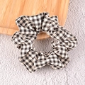 Detailopname van zwart-witte geruite scrunchie haarelastiek op een houten dienblad - Zwarte Ruit