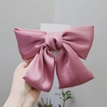 Detail of a large pink satin bow hair clip with polished texture and spring fastener - Pink Bowknot