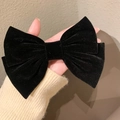 Macro view of a large black velvet bow hair clip showing plush texture and layered design - Black Velvet