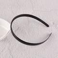 Détail d'un serre-tête en plastique noir avec dents antidérapantes sur fond de pierre - Bord étroit / Noir