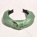 Dettaglio del cerchietto largo in raso verde salvia con nodo decorativo e interno antiscivolo - Verde