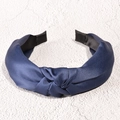 Dettaglio di un cerchietto in raso blu navy con elegante trama di seta e design con nodo - Blu