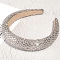 Detailed macro view of sparkling rhinestone padded headband with plush velvet inner lining - Silver