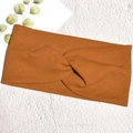 Dettaglio della fascia in maglia a costine color caramello con nodo su sfondo bianco - Marrone