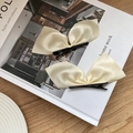 Set di due fermagli per capelli in raso beige crema con fiocco su una scrivania minimalista - Bianco Sporco