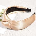 Detail of champagne satin knotted headband showing silk texture and non-slip velvet lining - Champagne