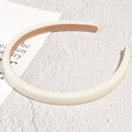 Detalle de diadema de satén crema con forro antideslizante marrón sobre un fondo blanco - Blanco (1.2cm)
