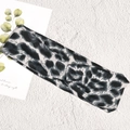Detail des geknoteten Stirnbands mit Leopardenmuster aus schwarz-grauem Strickstoff - Leopardenmuster Blaugrün