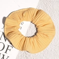 Macro detail of yellow pleated chiffon hair scrunchie with fine vertical textures - Yellow