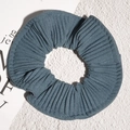 Detailed view of blue-grey striped fabric scrunchie with soft pleated texture and elastic design - Blue