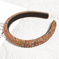 Primer plano de diadema ancha con diamantes de imitación coloridos en fondo de mármol - Pavimento Colorido