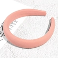 Close-up of light pink padded sponge headband with ribbed cotton texture on stone surface - Deep Pink