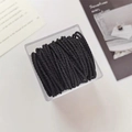 Primer plano de gomas de pelo en espiral negras organizadas en caja transparente - Negro
