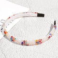 Detalle de diadema de cristales coloridos con forro de satén sobre fondo de piedra - Diamante de Imitación Irisado Blanco