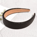 Detail of black faux leather headband with snake texture on white marble background - Black