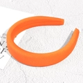 Detailansicht eines dicken orangefarbenen Satin-Schwamm Stirnbands auf weißem Grund - Orange