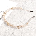 Detailed view of beige headband with crystal beads, pearls, and gold-set rhinestones - White