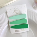 Dettaglio di tre mollette per capelli opache verde sfumato su cartoncino decorato - goccia / Verde