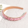 Detalle de piedras rosas y bordes de pedrería dorada en una diadema de estilo barroco - Rosa