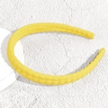 Detailed view of yellow plaid fabric headband with padded texture on white pedestal - Fine Yellow