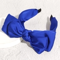 Diadema de satén azul real con lazo grande sobre soporte de exhibición blanco - Azul