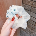 Dettaglio ravvicinato di un elastico in organza bianca con cuori colorati e ruches - Bianco Sporco