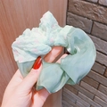 Dettaglio ravvicinato dell'elastico per capelli in organza verde menta e tessuto a cuori - Verde