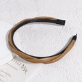 Detalle de la diadema de cuero marrón trenzado con dientes antideslizantes y estilo elegante - Marrón