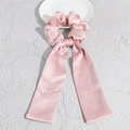 Vue détaillée d'un chouchou en satin rose avec rubans élégants et perles blanches - Rose