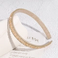Detail view of champagne crystal beads and non-slip teeth on a baroque style headband - Champagne