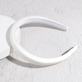 Details eines dicken weißen Satin-Haarreifs auf einem minimalistischen Display - Weiß