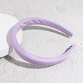 Close-up of a thick purple satin padded headband on a white circular display stand - Purple