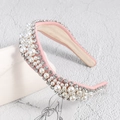 Détail d'un serre-tête en tissu rose avec perles et strass sur support en céramique - Rose