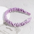 Vista detallada de la diadema de satén plisado lila con textura sedosa y brillo elegante - Morado