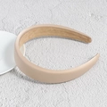 Dettaglio di un cerchietto largo in raso beige con fodera in pelle scamosciata su pietra - Cachi
