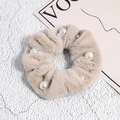 Gros plan sur un chouchou élégant en peluche beige avec des perles blanches - Kaki